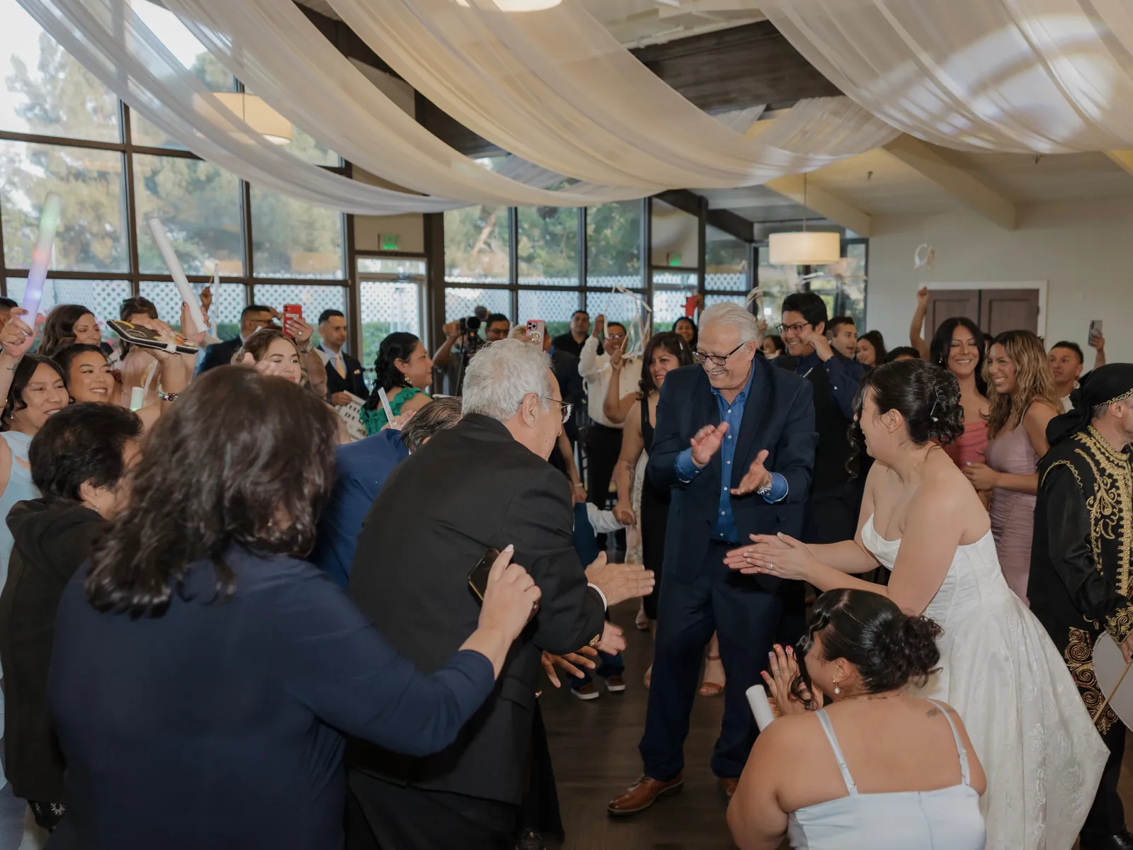The bride and guests clapping in a circle on a packed dance floor at Knollwood Country Club in Granada Hills